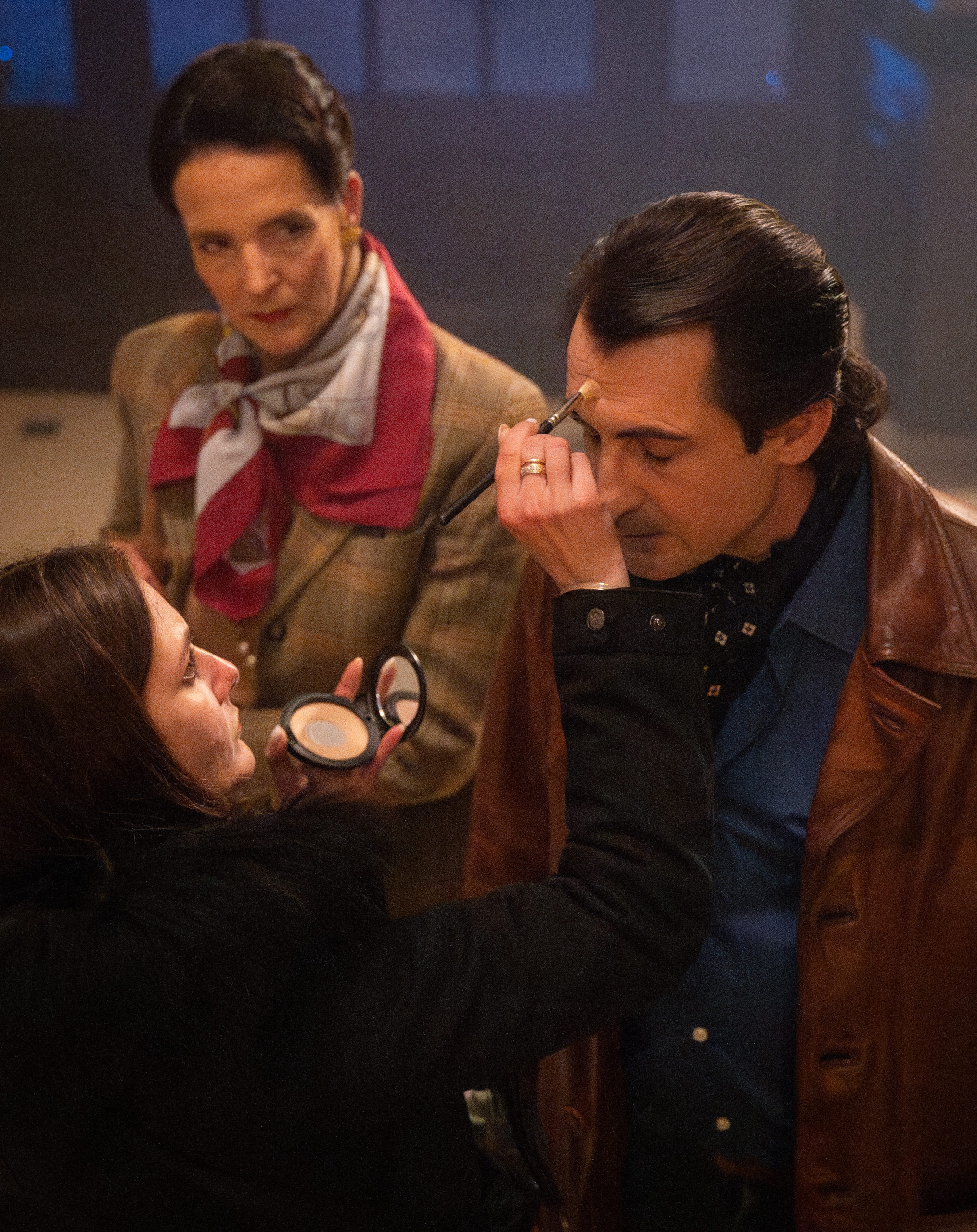 Julia Marty fait une retouche maquillage à un comédien et une comédienne.