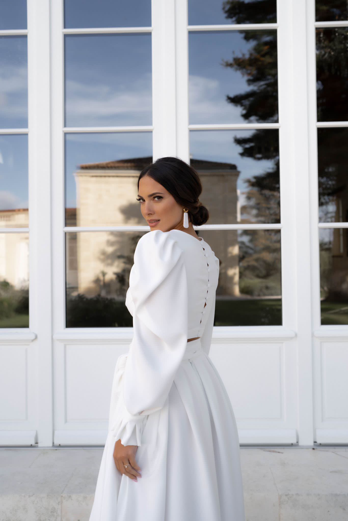 Une mariée brune à la peau dorée avec un maquillage lumineux et structuré dans les tons de bruns.