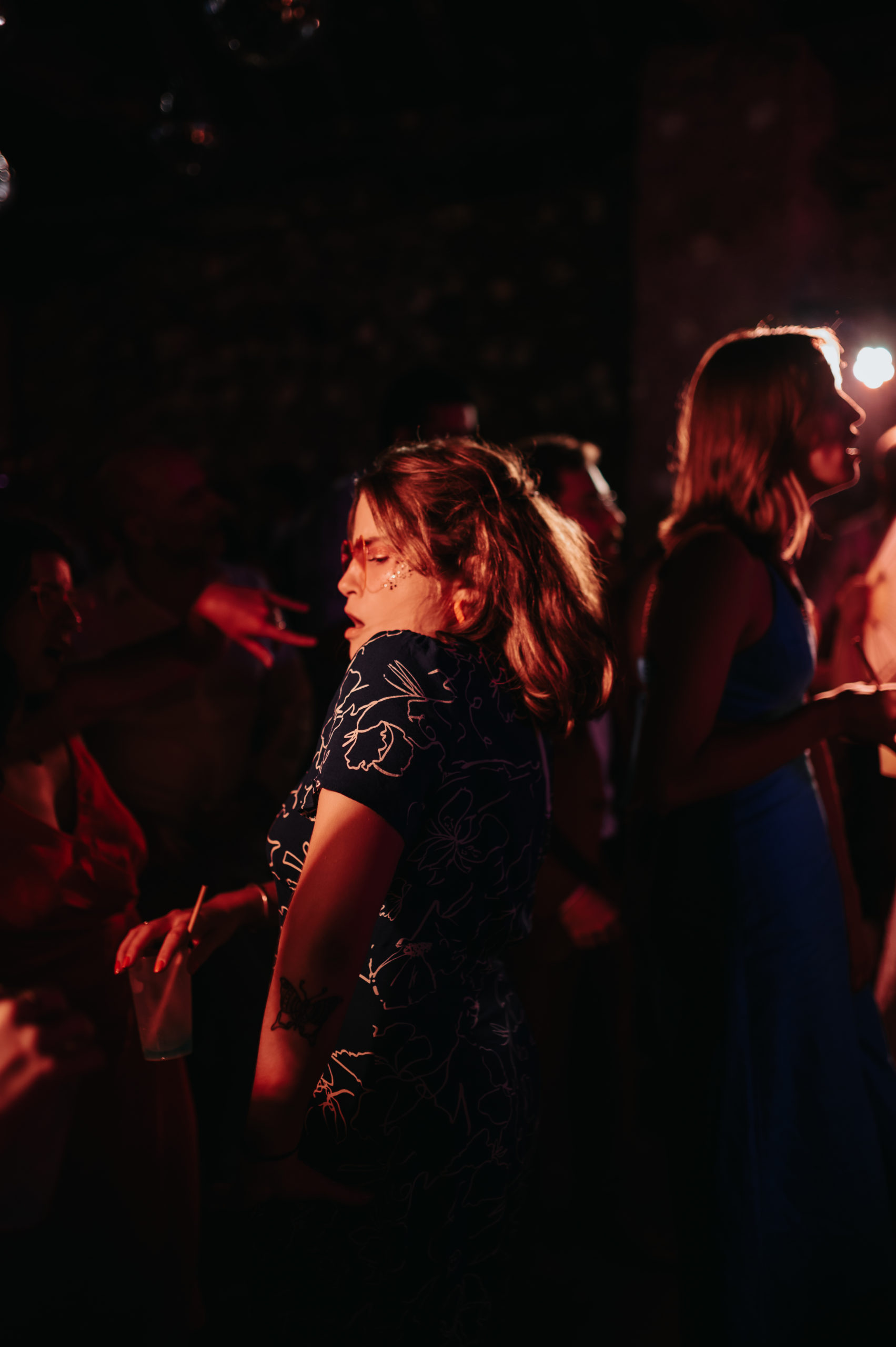 Une femme qui danse avec des paillettes sur le visage.
