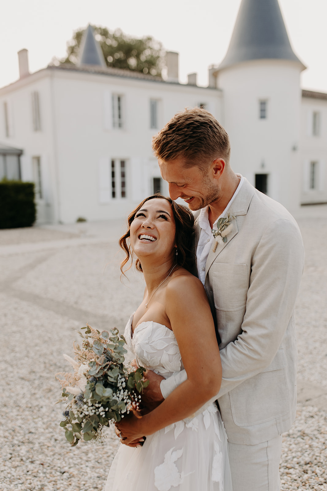 Un couple de mariés. La mariée est brune, d'origine sud américaine avec un maquillage naturel et sophistiqué dans les tons chauds.