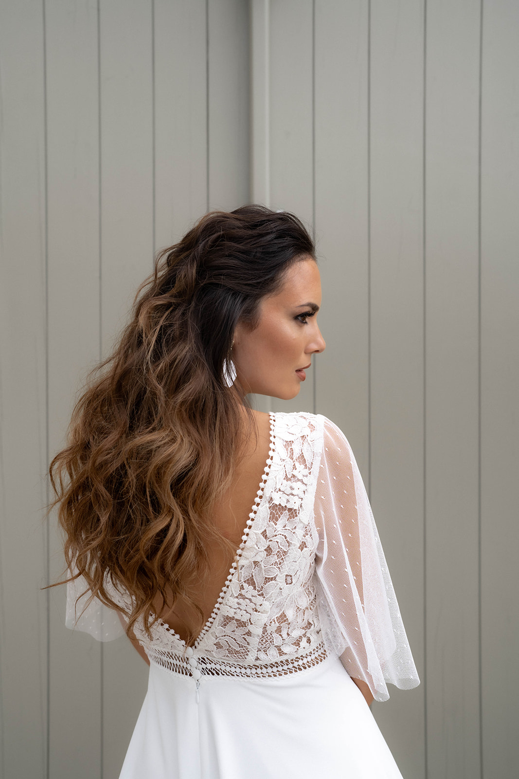 Une mariée de quart, chatain au cheveux bouclé avec un maquillage sophistiqué brun.